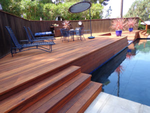 A treated and protected elevated pool deck made of redwood.