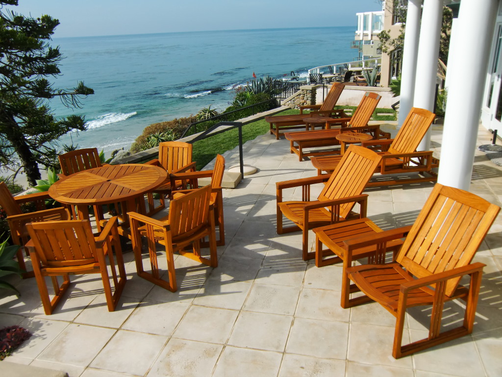Wooden teak furniture on a patio overlooking the ocean in California