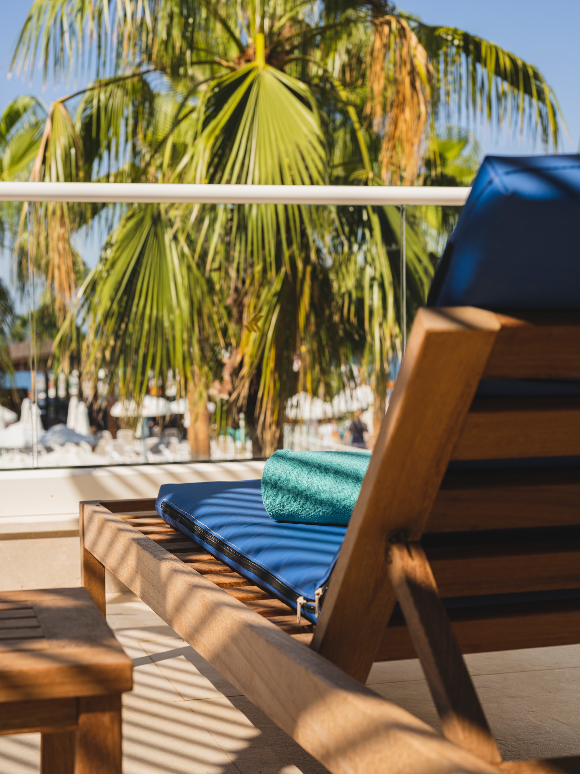 A wooden lounge chair on a deck by the beach
