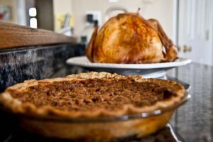 Pecan pie and turkey sitting on a kitchen counter for Thanksgiving dinner