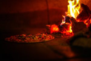 Pizza cooking in a wood fire grill