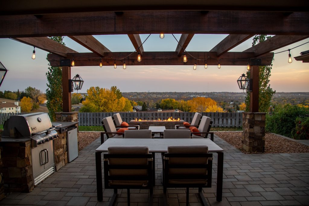 Backyard patio decorated with outdoor furniture and a wooden pergola