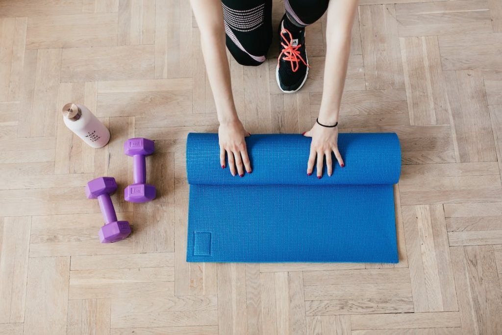 Woman rolling out a yoga mat at a yoga studio in Laguna Beach